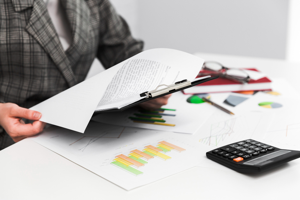 Escritorio con estados financieros, calculadora y documentos contables