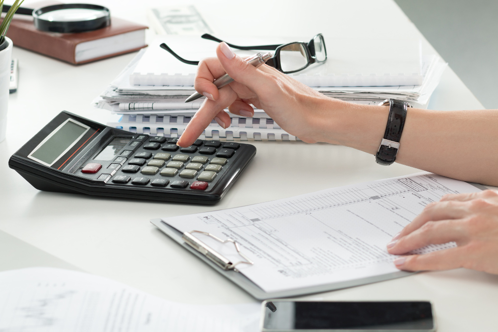 Formulario de declaración fiscal, calculadora y trámites del SAT sobre un escritorio